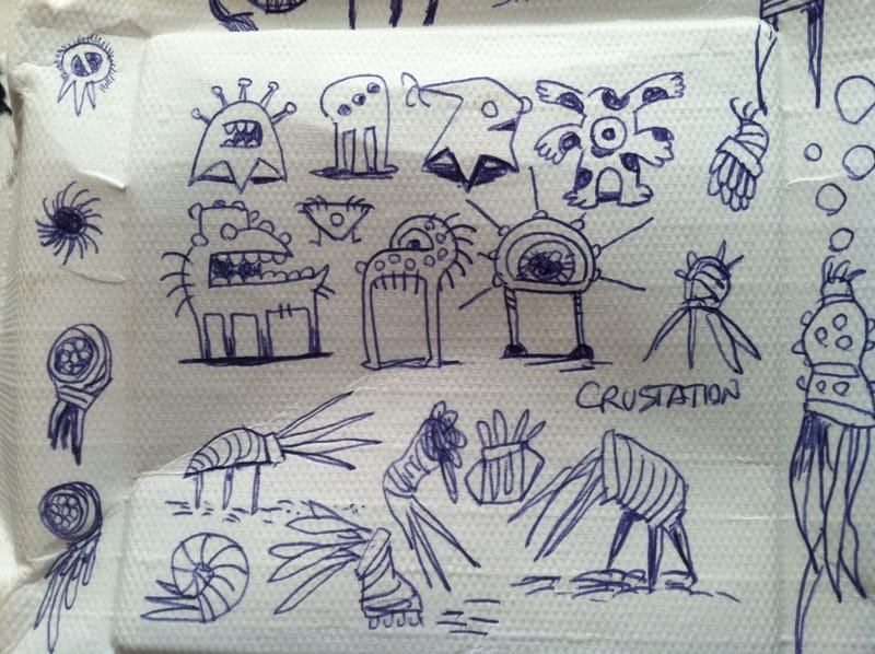Blue ballpoint doodles of microbe characters on a crumpled paper napkin, one labeled Crustation.