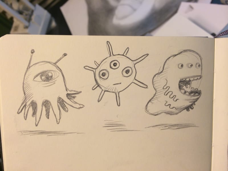A sketchbook page with three pencil microbes: one with tentacles and a single eye, a spiky ball, and a gaping blob.